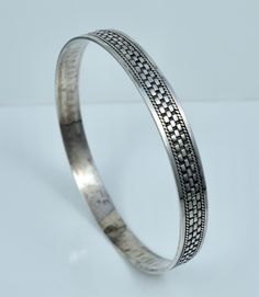 A lovely bangle.  This vintage bangle features a woven style design and is crafted from solid sterling silver. It is clearly hallmarked "BA 925", weighs 14.9 grams, measures just over 1/4 inches wide, and has an inner circumference of 8 1/8 inches. Overall good condition, slightly out of round.  Please ask any questions, always open to offers, and free shipping anywhere in the USA! Traditional Silver Braided Bracelet With Jubilee Style, Oxidized Sterling Silver Bangle Bracelet, Engraved Silver Braided Bangle Bracelets, Silver Engraved Braided Bangle Bracelets, Classic Sterling Silver Bangle With Intricate Design, Engraved Sterling Silver Braided Bangle Bracelets, Bohemian Sterling Silver Jubilee Bangle Bracelet, Traditional Silver Braided Bangle Bracelet, Hallmarked Sterling Silver Bangle Bracelet