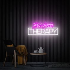 a neon sign that says but not therapy on the wall next to a table with a teapot