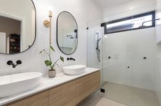 a bathroom with two sinks and mirrors on the wall