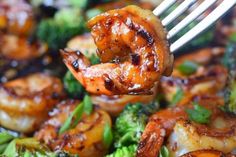 shrimp and broccoli being lifted with a fork