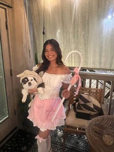 a woman in a pink dress is holding a panda doll and posing for the camera