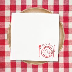 a red and white checkered table cloth with a place setting