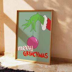 a christmas poster with the grinch hanging from it's frame