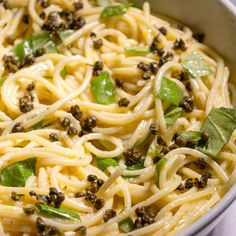 a bowl filled with pasta and greens on top of a table