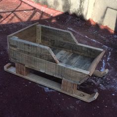 a wooden crate sitting on top of snow covered ground next to a wall and stairs