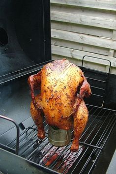 a chicken sitting on top of a bbq grill