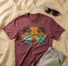 Embrace the ultimate summer vibes with our "Sun, Sea, Sand" T-Shirt from CreativeKinStudio. This vibrant design features a stunning tropical scene reflected in sunglasses, capturing the essence of a perfect beach day. Ideal for cruise enthusiasts, beach lovers, and anyone dreaming of a tropical getaway, this tee is a must-have addition to your summer wardrobe. Crafted from premium quality cotton, this t-shirt offers exceptional comfort and durability. Perfect for casual outings, beach trips, or Coastal Theme, Beach Lover Gifts, Holiday Apparel, Sea Sand, Beach Trips, Tropical Getaways, Beach Lover, Cruise Vacation, Beach Lovers