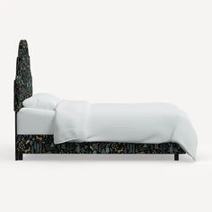 an upholstered bed with white linens and cactus patterned headboard is shown