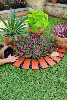 a woman laying on the ground next to potted plants in front of her house