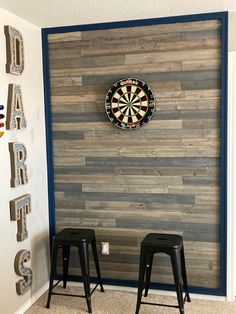 two stools in front of a dart board wall