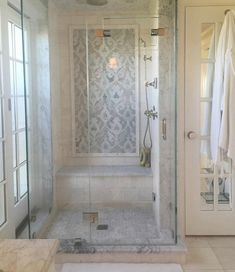 a bathroom with a walk in shower sitting next to a white door and window sill