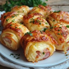 a white plate topped with cheesy pastries on top of a wooden table