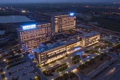 an aerial view of two large buildings at night, with lights on the top and bottom floors