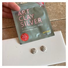 a packet of art clay silver on top of a white surface with two small buttons