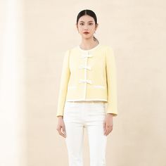 Crafted with a premium light yellow textured fabric reminiscent of the iconic Coco Chanel style, this jacket exudes sophistication and elegance. The subtle shimmer adds a touch of luxury, making it a valuable addition to your wardrobe.Featuring a short boxy silhouette, the jacket offers versatility and comfort. The classic round neckline complements all body types, ensuring a flattering fit without constraints.Adding to its charm, the jacket is designed with a hint of relaxed volume in the silhouette, creating a perfect balance. The contrast trim in beige and delicate bow detail on the shoulders enhance the romantic vibe, while the light-colored interior lining adds a refreshing and vibrant touch. Chic Beige Tweed Jacket For Spring, Elegant Long Sleeve Tweed Jacket For Spring, Elegant Long Sleeve Spring Tweed Jacket, Chic Cream Tweed Jacket For Formal Occasions, Elegant Beige Tweed Jacket For Spring, Chic Spring Formal Tweed Jacket, Elegant Spring Evening Tweed Jacket, Chic Spring Tweed Jacket For Formal Occasions, Chic Cream Tweed Jacket For Spring