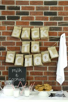 some cookies and milk are on a table next to a sign that says back to school