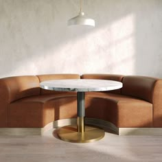 a round table sitting on top of a wooden floor next to a brown couch in a living room