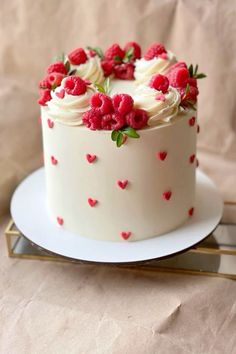 a white cake with raspberries and cream frosting