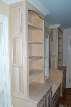 an empty room with wooden shelves and drawers