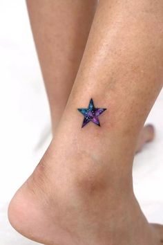 a woman's foot with a small star tattoo on it