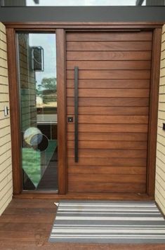 a modern wooden door with glass panels and sidelights on the outside of a house