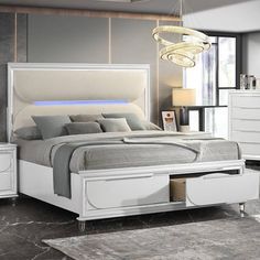 a white bed sitting in a bedroom next to a night stand with drawers on each side