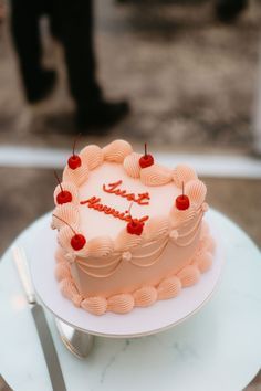 a birthday cake sitting on top of a white plate next to a knife and fork