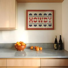 a bowl of oranges sitting on top of a kitchen counter