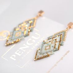 two pairs of earrings on top of a piece of paper with the word pencil written in it