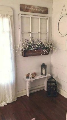 a room with white walls and wooden flooring has a window, potted plant on the wall