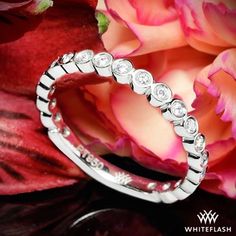 a diamond ring sitting on top of a flower