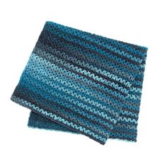 two blue and gray crocheted dishcloths sitting on top of each other