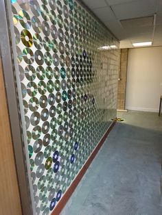 an office hallway with a wall made out of circles and dots on the glass door