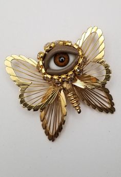 Mixed media art brooch.  Made with vintage costume jewelry, glass eye and rhinestone. Available alone or with display box.  Please see photos for condition and other details. Unique Handmade Collectible Pins, Glass Dolls, Mixed Media Jewelry, Insect Jewelry, Doll Eyes, Gold Butterfly, Vintage Brooch, Vintage Costume Jewelry, Media Art