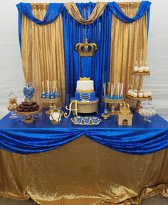 a blue and gold dessert table with lots of food on it's side,