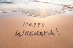 happy weekend written in sand on the beach