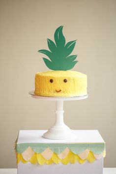 a yellow cake with a green pineapple on top