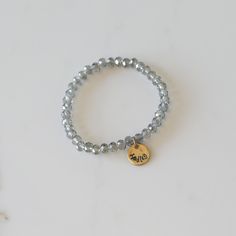 Add some bling to your wrist with our Personalized Crystal Stacks! You can personalize your stack bracelet with a name, date, initials, or a word of choice on a simple, classic disc charm. With neutral colors and faceted beads that shine and shimmer in the light, you can be reminded of a motivating word, memory, or special loved one whenever you look down at your wrist! A perfect gift for the everyday stack wearing lover! *Elastic stack bracelets are made with 6mm faceted crystals *Personalized Everyday Silver Charm Bracelet With Custom Name, Adjustable Nickel-free Name Bracelet For Everyday, Silver Stackable Charm Bracelet For Everyday, Silver Customizable Name Bracelet For Everyday, Customizable Silver Name Bracelet For Everyday, Everyday Stackable Round Name Bracelet, Silver Spiritual Stretch Bracelet For Everyday, Adjustable Round Name Bracelet For Everyday, Personalized Adjustable Crystal Bracelet