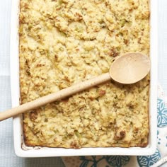 a casserole dish with a wooden spoon in it on a blue and white cloth