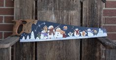 a pair of scissors sitting on top of a piece of fabric with snowmen in the background