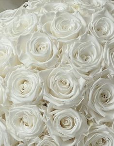 a bouquet of white roses sitting on top of a table