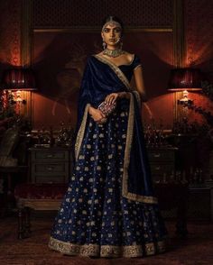 Blue Silk Velvet Lehenga -Bridal Collection Blouse Piece : Stitched Lehenga & Blouse is free size: Adjustable upto 28 to 44 inches Lehenga Length: 43 inches long With Cane $10 chargeable  (Length & Chest have 1 n 1.5 inches +/-) With Net Dupatta Fabric: Soft  Fine Silk Velvet Lehenga & Blouse Work: Laces attached Care : DryClean Note: Visual Samples on website may differ slightly from actual product due to light & effects during photography NOTE : Before placing order ,pls confirm product n color availability on +91 7903893945 & +91 8447750028(WhatsApp) NOTE : For Wholesale Order MOQ is 5 Pieces of any color/Pattern contact on +91 7903893945 & +91 8447750028(WhatsApp) Diwali Gown With Unstitched Dola Silk Blouse, Dola Silk Gown For Diwali, Blue Traditional Drape Gown For Diwali, Elegant Semi-stitched Royal Blue Dupatta, Royal Blue Wedding Dress With Pallu, Bollywood Gown With Pallu For Diwali, Royal Blue Dresses For Wedding And Navratri, Royal Blue Wedding Dress For Navratri, Festive Traditional Drape Gown With Unstitched Blouse