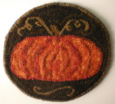 an orange and black rug on top of a white wall