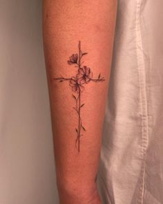 a cross and flowers tattoo on the leg