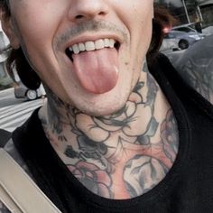 a man with tattoos sticking out his tongue