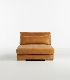 a brown leather chair sitting on top of a white floor