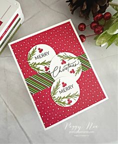 two christmas cards sitting next to each other on top of a white table with red and green decorations