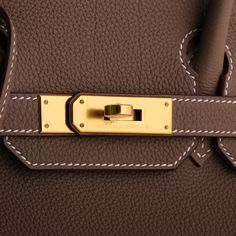 This exquisite Birkin bag, crafted in Etoupe Togo leather, features elegant gold hardware and contrasting stitching. The design includes a front flap with two straps secured by a center toggle closure, a clochette with a lock and two keys, and double rolled handles. The interior, lined with etoupe chevre leather, boasts a zip pocket with an Hermès engraved zipper pull and an open pocket on the opposite side, offering both style and functionality. Leather: Togo Hardware: Gold Style: Birkin Condit