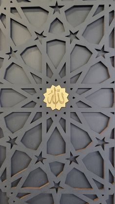 an intricately designed wall with gold arabic calligraphy in the center and on the side