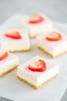 four pieces of cheesecake with strawberries on top